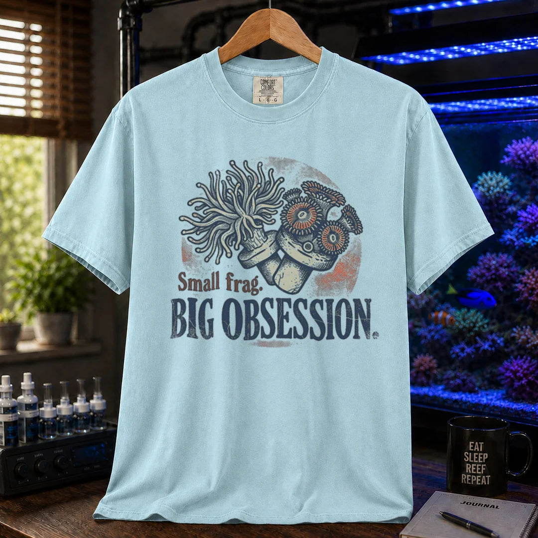 Saltwater aquarium graphic t-shirt on a pure solid white fabric background featuring an illustration of coral frags and text: Small frag. BIG OBSESSION., blue crew neck tee