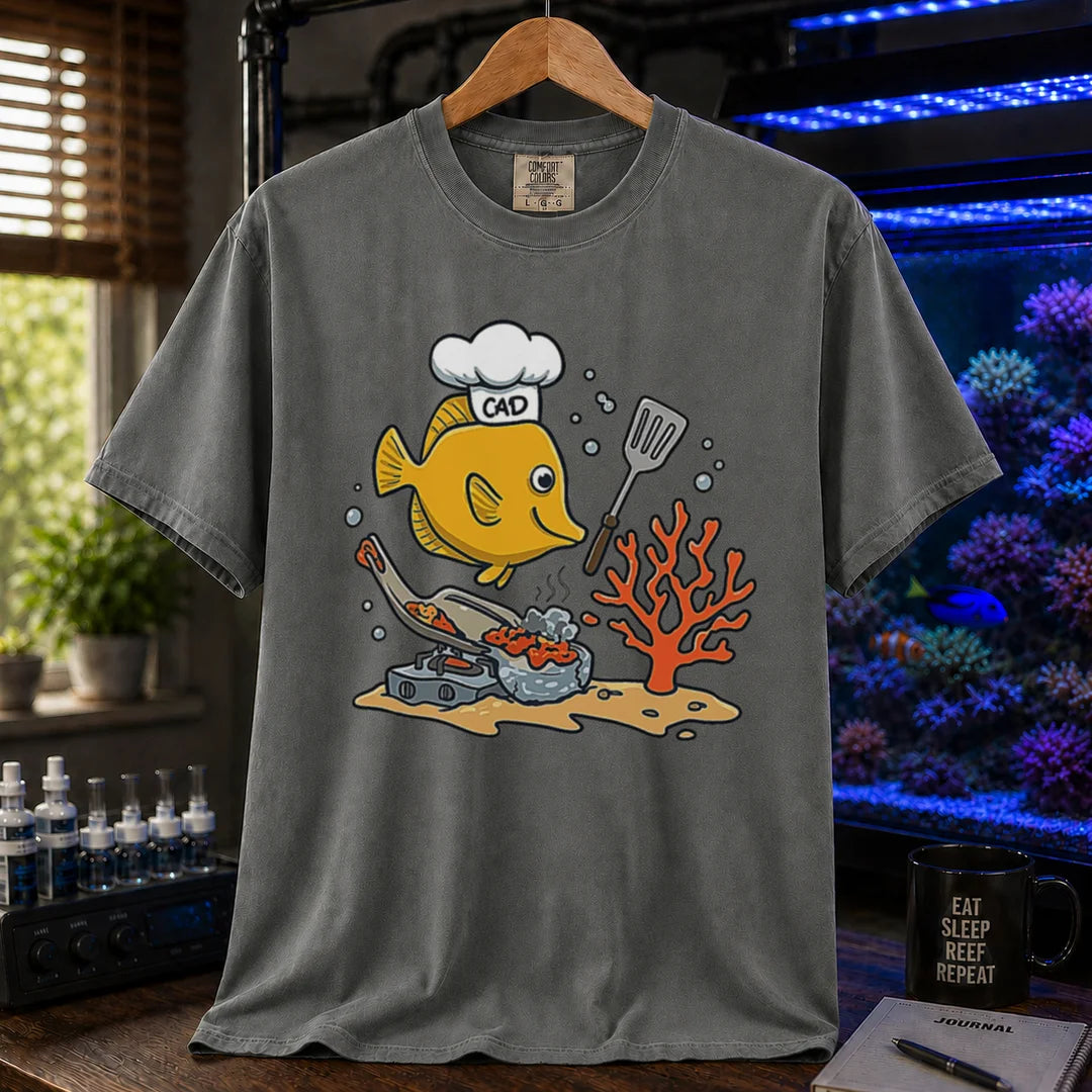 Saltwater aquarium graphic t-shirt featuring a yellow Tang wearing a chef hat and cooking with a spatula over a stove, khaki crew neck tee