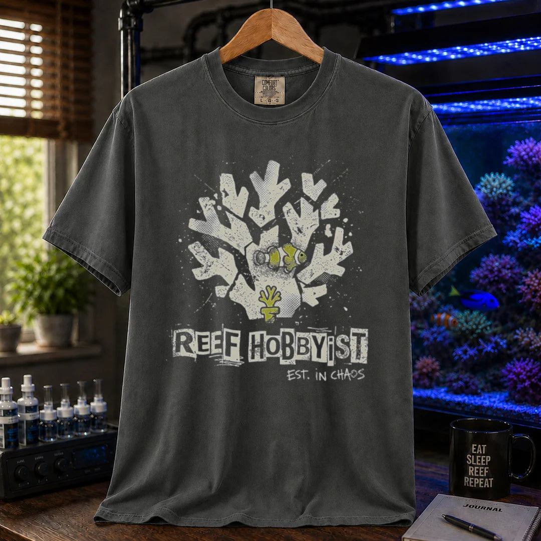 Saltwater aquarium graphic t-shirt featuring a distressed branching coral illustration with a clownfish and text: REEF HOBBYIST EST. IN CHAOS, khaki crew neck tee