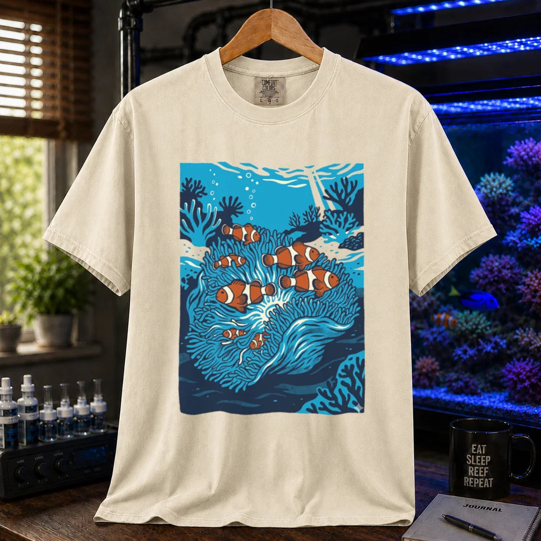 Saltwater aquarium graphic t-shirt featuring a vibrant illustration of multiple clownfish in a blue anemone biotope, cream, beige, ivory crew neck tee