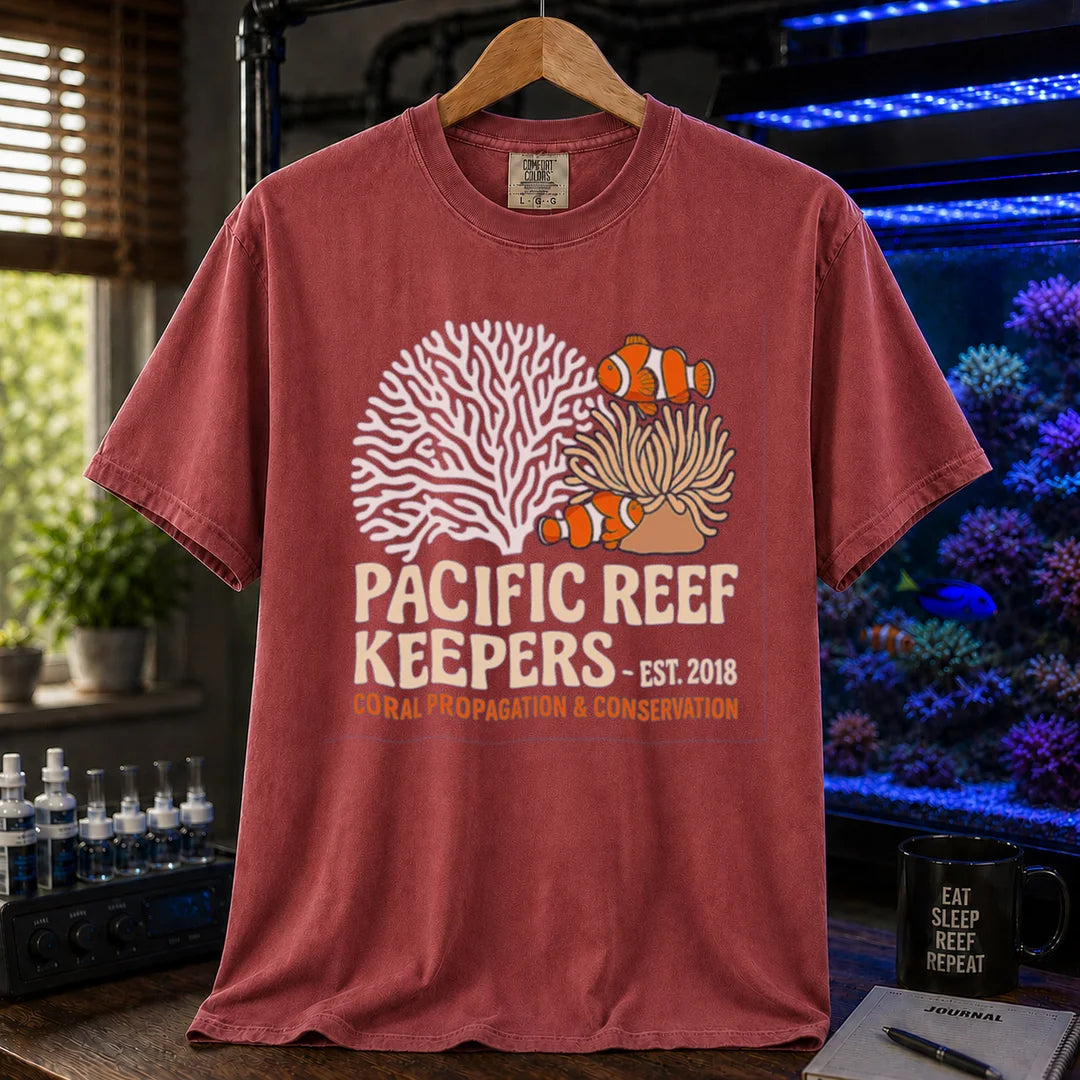 Saltwater aquarium graphic t-shirt featuring clownfish, anemone, and coral illustrations with text: PACIFIC REEF KEEPERS - EST. 2018 SUSTAINABLE REEFKEEPING, maroon, red crew neck tee