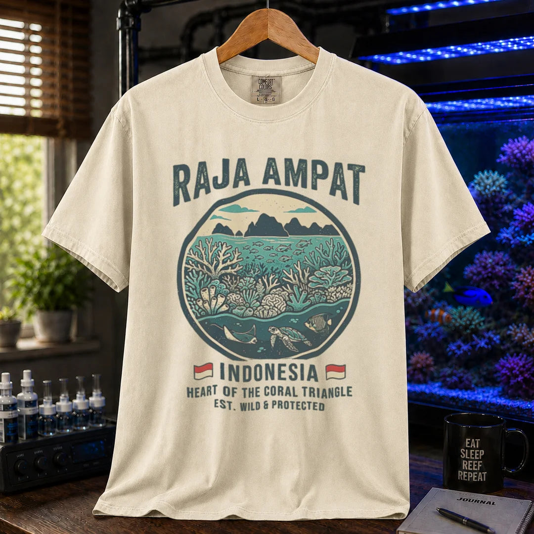 Saltwater aquarium graphic t-shirt featuring a circular reef landscape illustration and text: RAJA AMPAT INDONESIA HEART OF THE CORAL TRIANGLE EST. WILD & PROTECTED, cream, beige, ivory crew neck tee