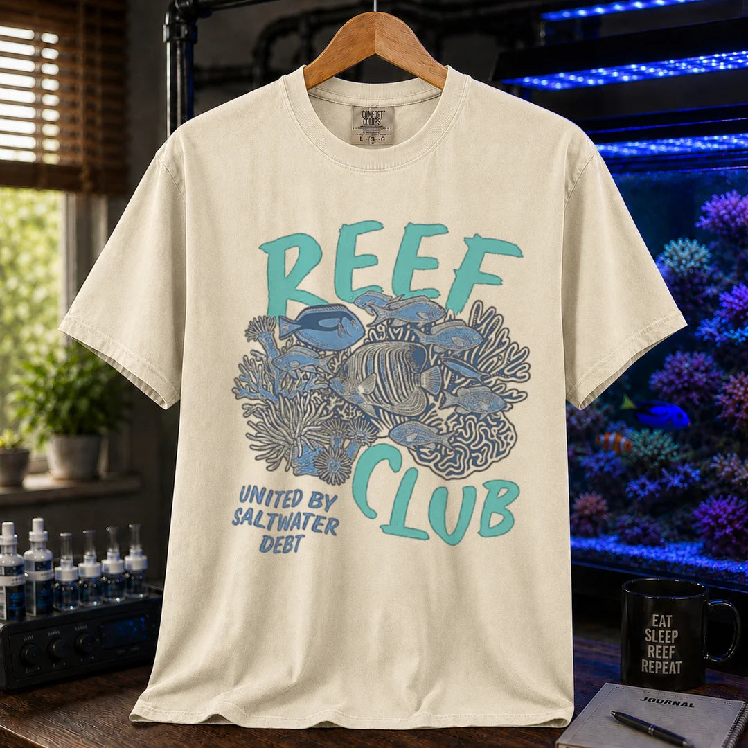 Saltwater aquarium graphic t-shirt featuring a detailed reef and fish illustration with text: REEF CLUB UNITED BY SALTWATER DEBT, cream, beige, ivory crew neck tee