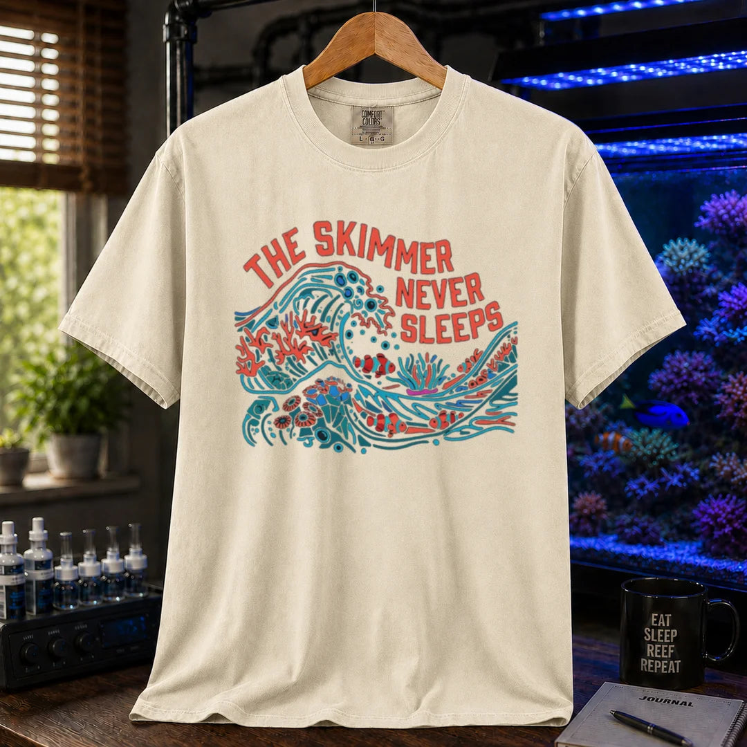 Saltwater aquarium graphic t-shirt featuring a colorful wave and reef illustration with text: THE SKIMMER NEVER SLEEPS, cream, beige, ivory crew neck tee
