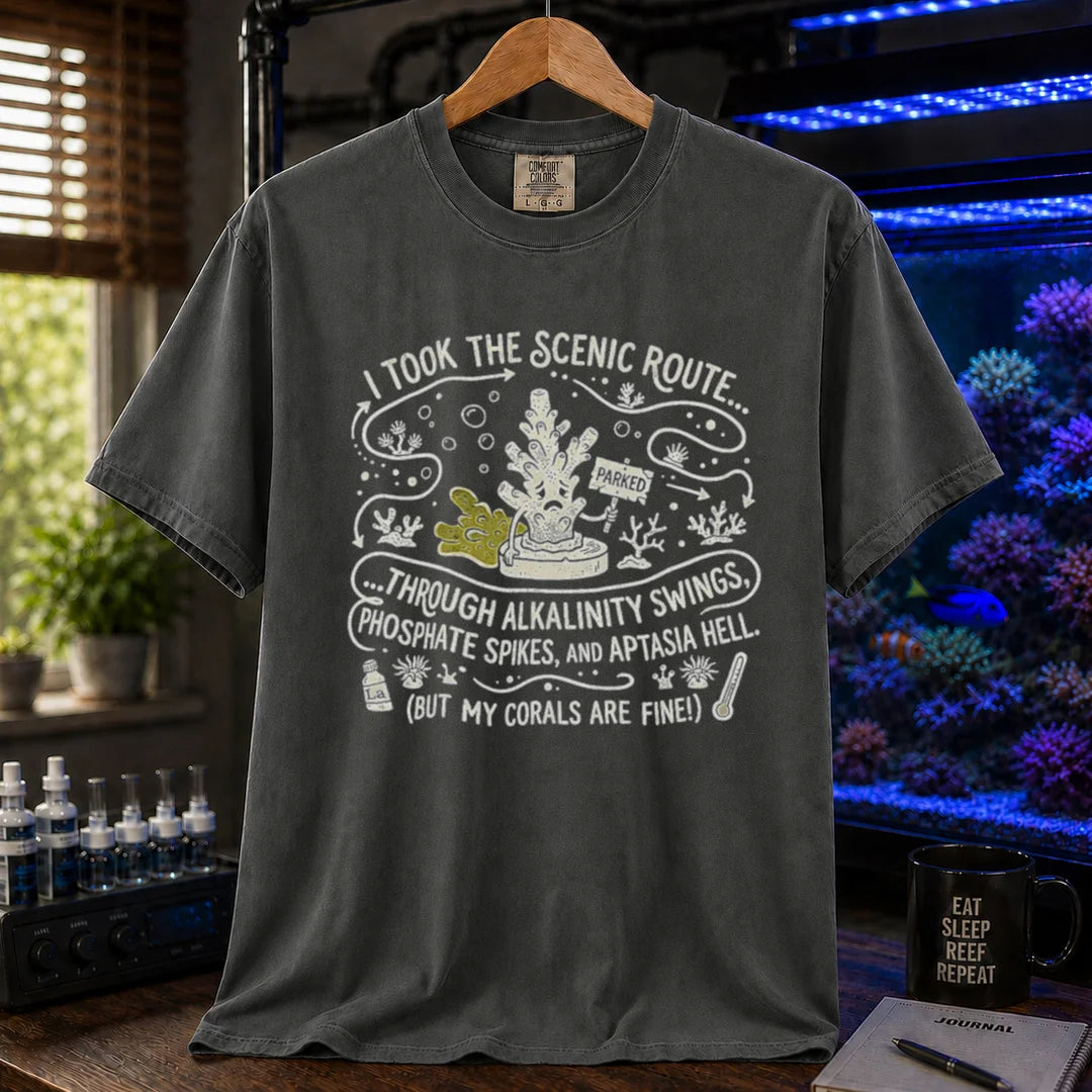 Saltwater aquarium graphic t-shirt featuring an illustrative map design with a coral character and text: I TOOK THE SCENIC ROUTE... THROUGH ALKALINITY SWINGS, PHOSPHATE SPIKES, AND APTASIA HELL. (BUT MY CORALS ARE FINE!), dark grey crew neck tee