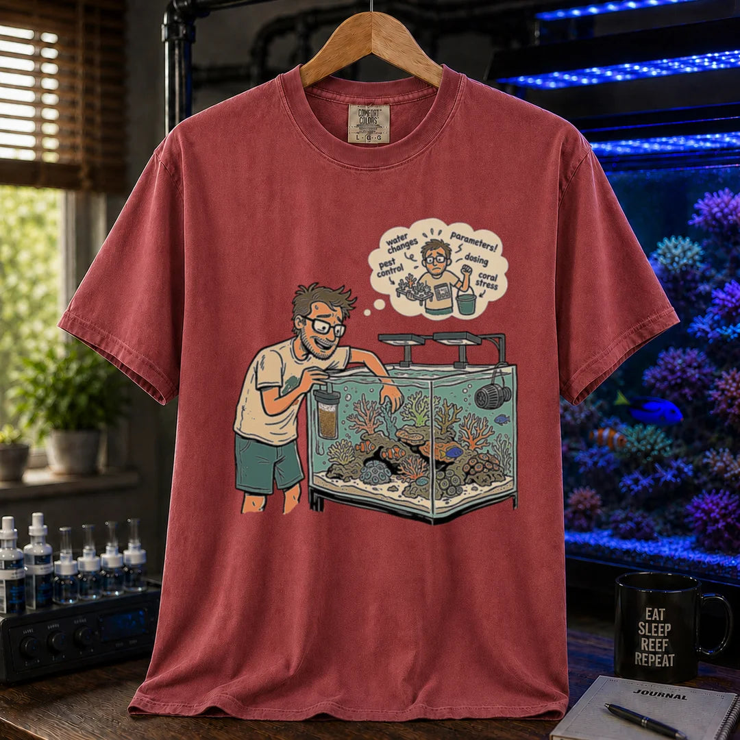 Saltwater aquarium graphic t-shirt featuring an aquarist maintaining a tank with a thought bubble of reef chores, maroon, red crew neck tee