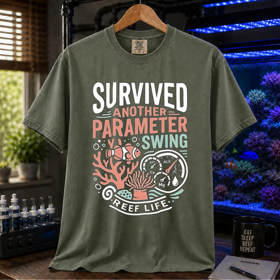 Saltwater aquarium graphic t-shirt featuring a clownfish, coral, parameter gauges, and text: SURVIVED ANOTHER PARAMETER SWING REEF LIFE, military green crew neck tee