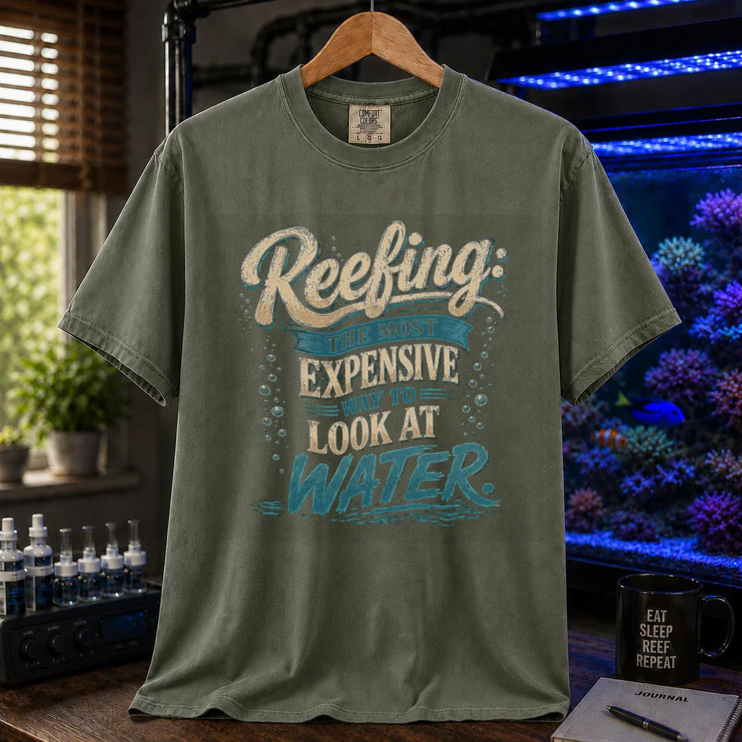 Saltwater aquarium graphic t-shirt featuring cream and blue typography reading Reefing: The Most Expensive Way To Look At Water with bubble accents, military green crew neck tee