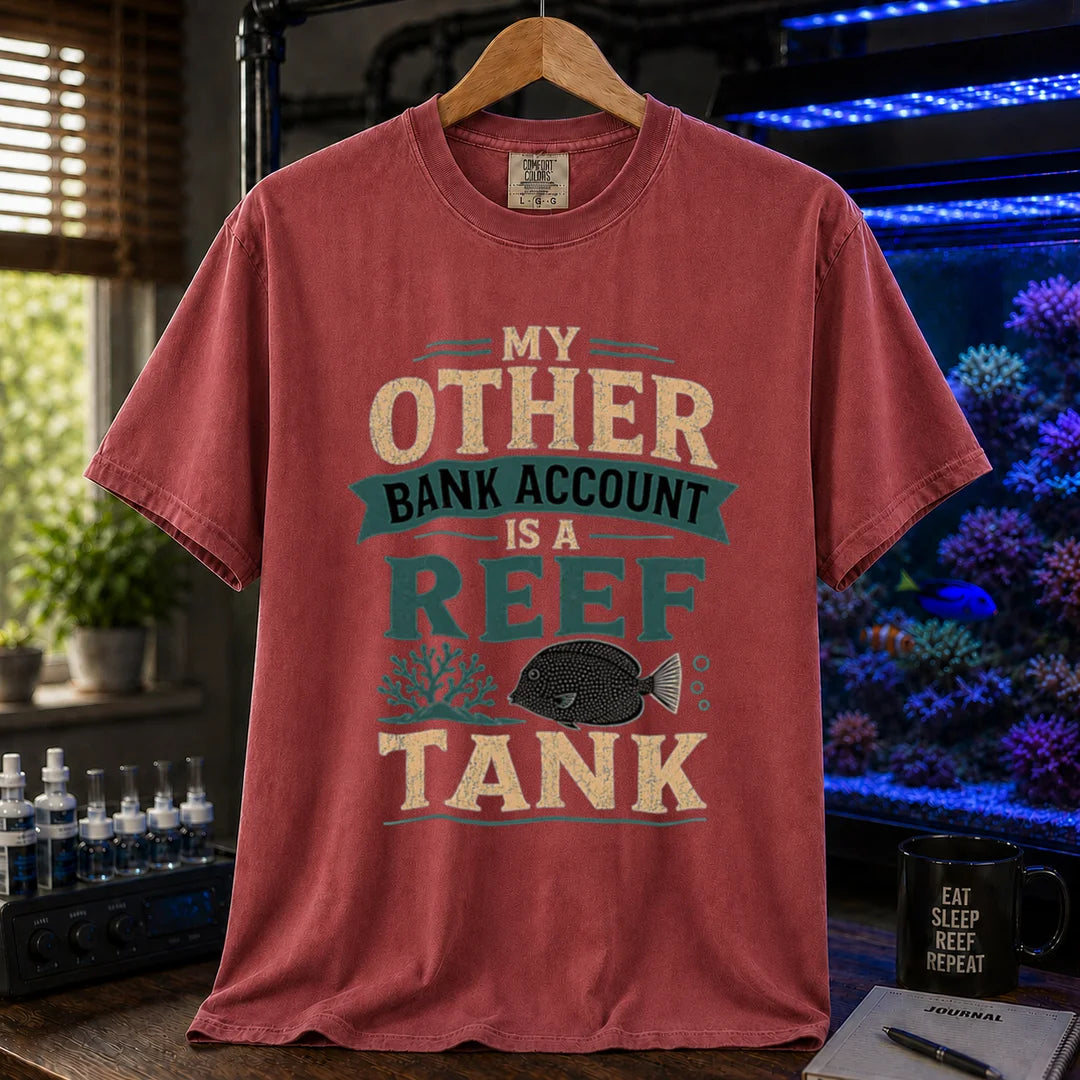Saltwater aquarium graphic t-shirt featuring cream and teal distressed typography reading My Other Bank Account Is A Reef Tank with coral and tang illustrations, maroon, red crew neck tee