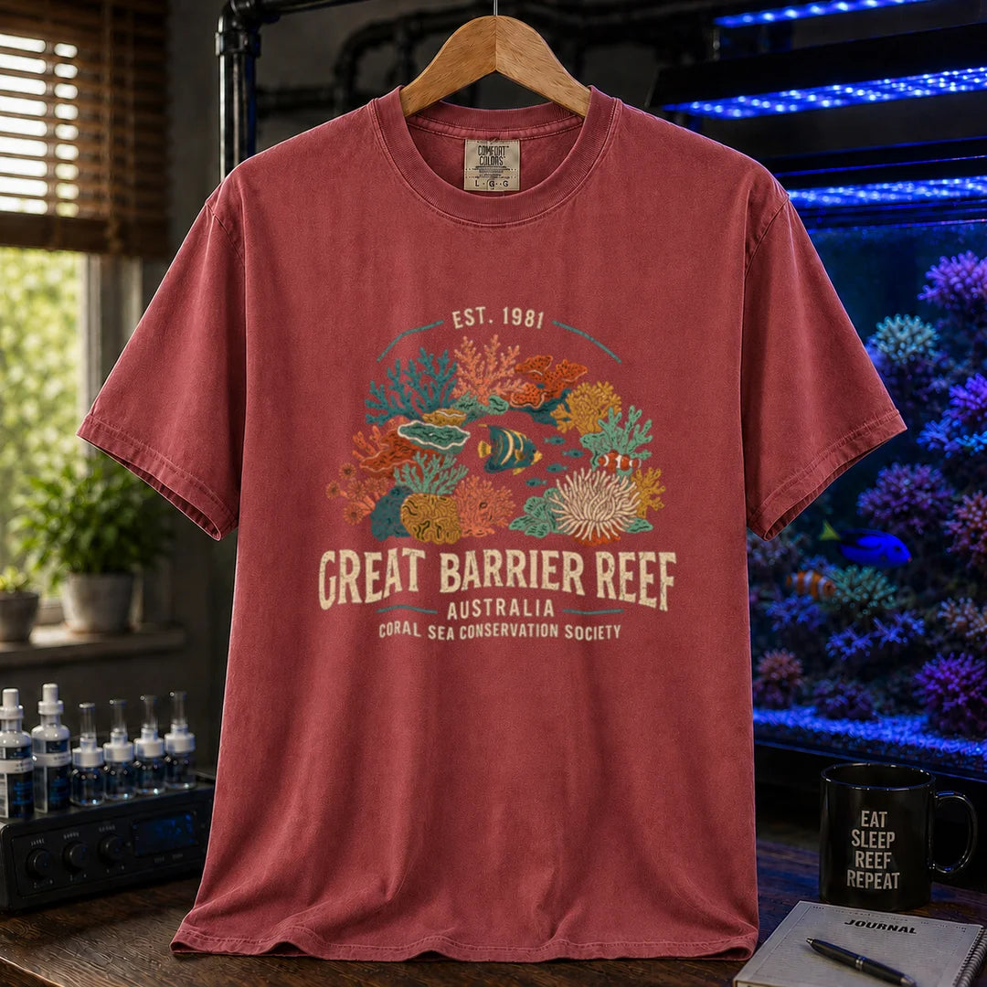 Saltwater aquarium graphic t-shirt featuring detailed vintage illustration of coral reefs and tropical fish with text reading Great Barrier Reef Australia Coral Sea Conservation Society Est. 1981, maroon, red crew neck tee