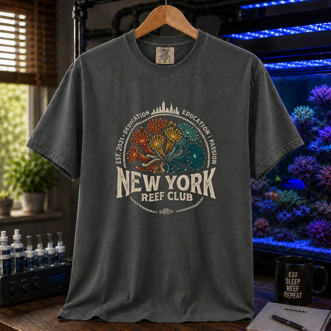 Saltwater aquarium graphic t-shirt featuring vintage emblem design with New York skyline, coral polyps, and text reading New York Reef Club Est. 2021 Dedication Education Passion, dark grey crew neck tee