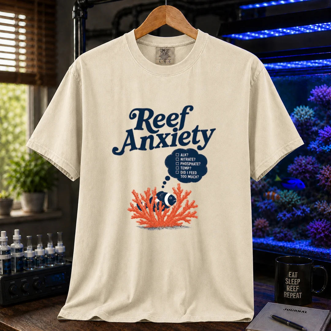 Saltwater aquarium graphic t-shirt featuring blue text reading Reef Anxiety and an illustration of a clownfish in coral with a thought bubble checklist, cream, beige, ivory crew neck tee