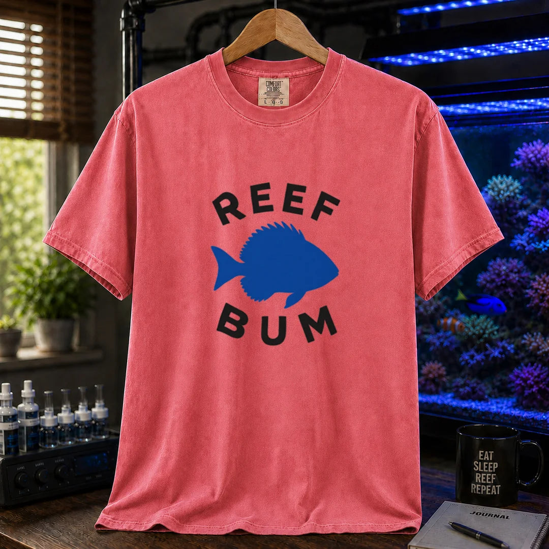 Saltwater aquarium graphic t-shirt featuring bold black typography reading Reef Bum arched around a solid blue silhouette of a fish on a watermelon background