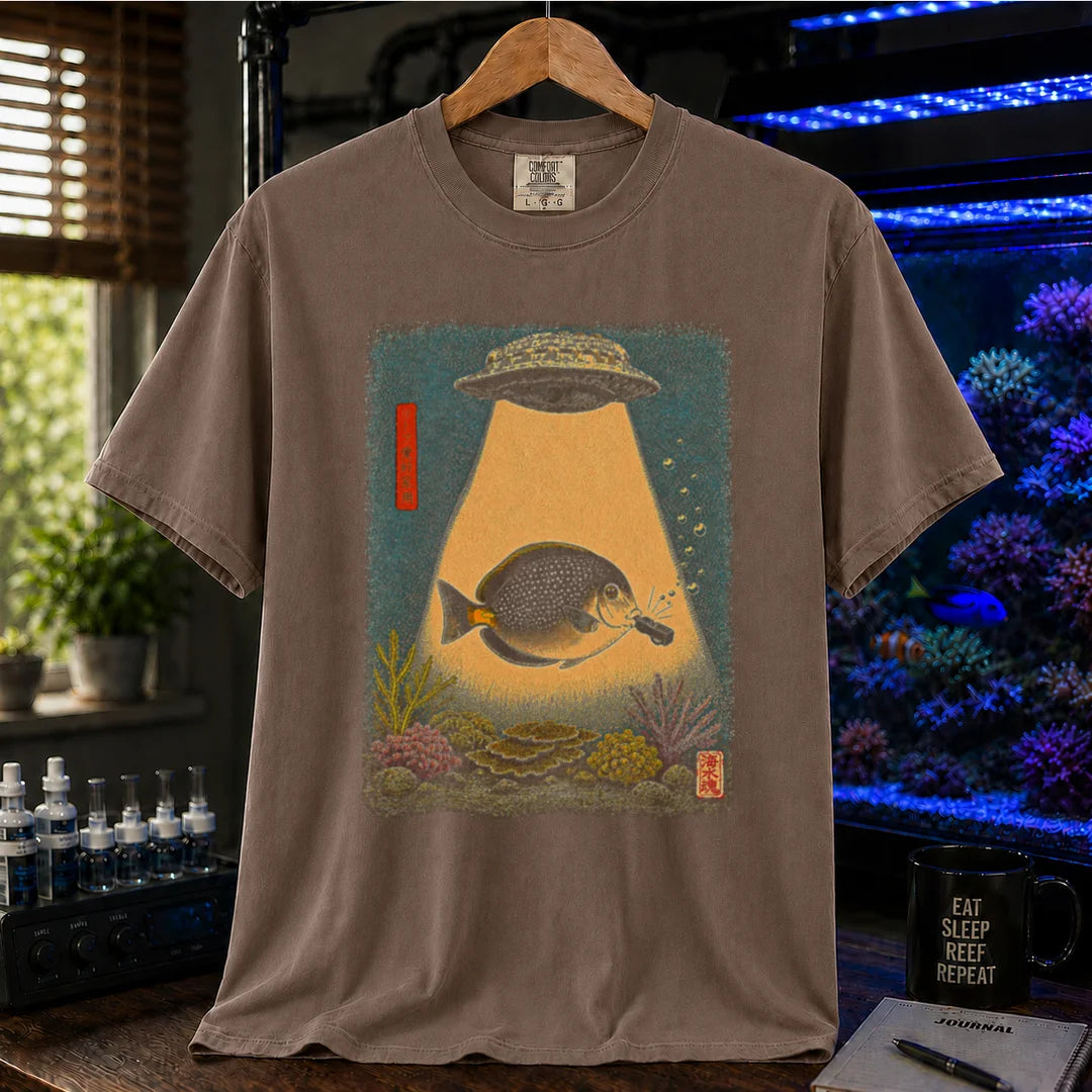 Saltwater aquarium graphic t-shirt featuring a vintage woodblock print style UFO abducting a reef fish with a tractor beam over coral on a brown shirt