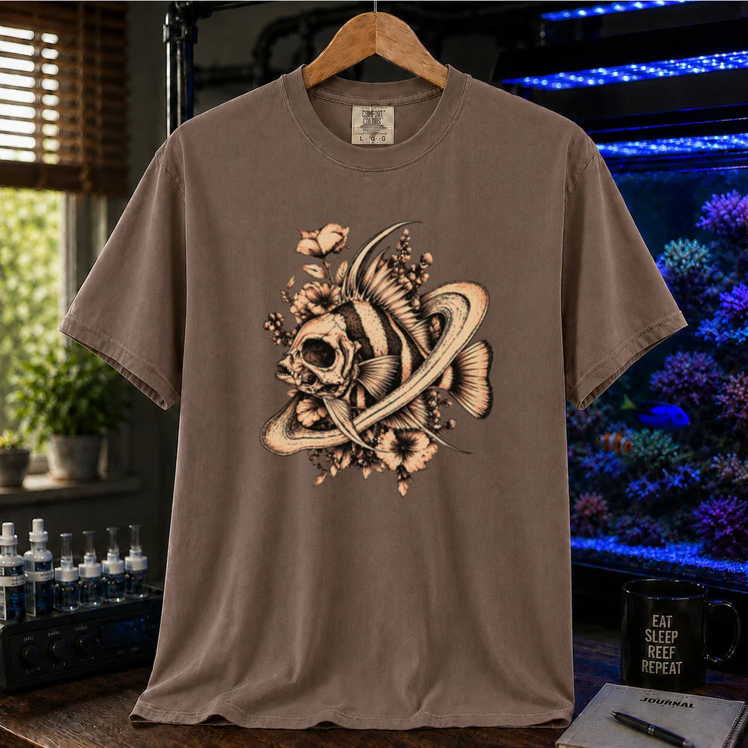 Saltwater aquarium graphic t-shirt featuring an intricate sepia line-art illustration of a fish skull surrounded by flowers and swirling rings on a brown shirt