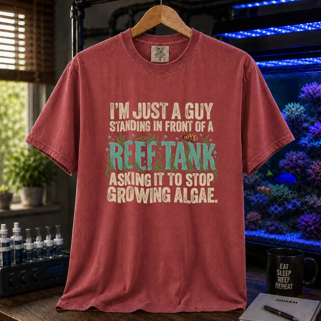 Saltwater aquarium graphic t-shirt featuring typography reading I'm Just A Guy Standing In Front Of A Reef Tank Asking It To Stop Growing Algae with algae and a clownfish on a maroon, red shirt