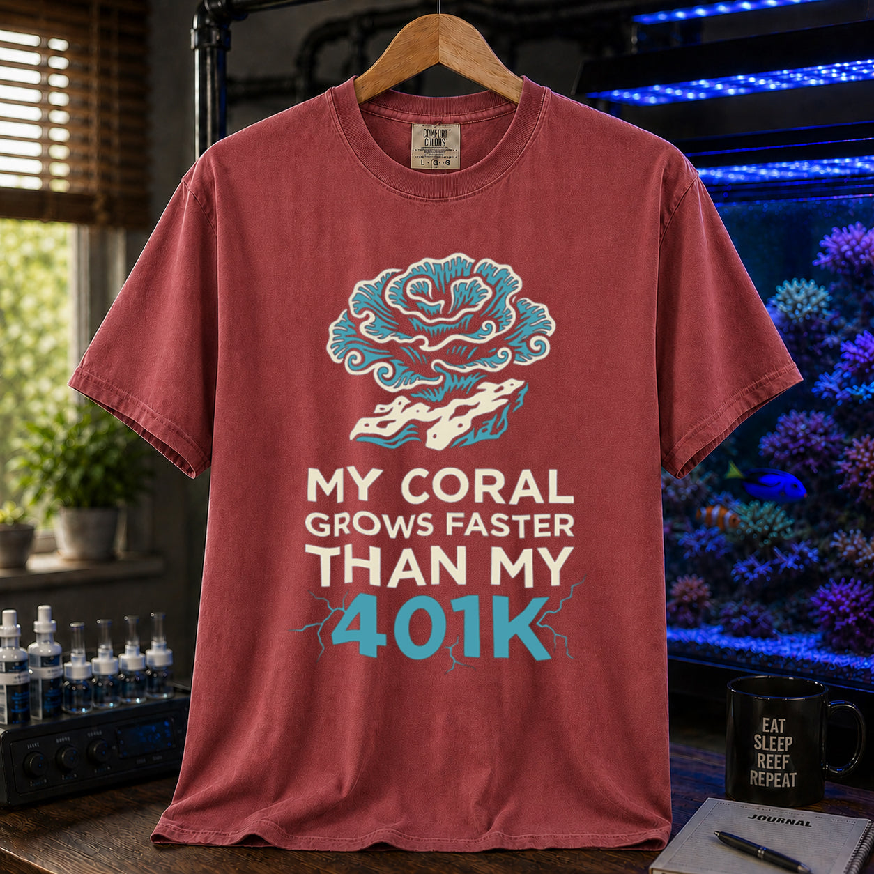 Broke Reefers saltwater aquarium graphic t-shirt featuring an intricate coral illustration and electric blue and white text: MY CORAL GROWS FASTER THAN MY 401K, maroon crew neck tee