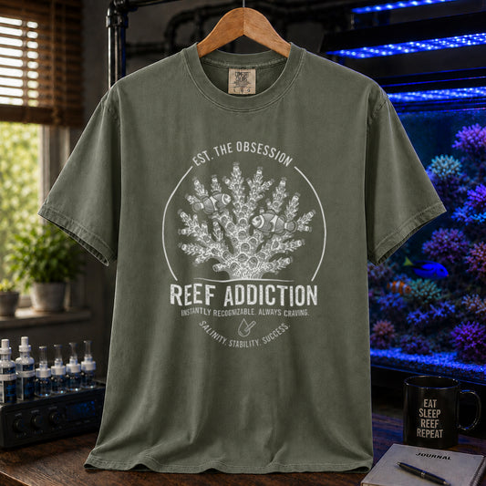 Broke Reefers saltwater aquarium graphic t-shirt featuring a circular emblem with coral, clownfish, and text: EST. THE OBSESSION, REEF ADDICTION, INSTANTLY RECOGNIZABLE. ALWAYS CRAVING, SALINITY. STABILITY. SUCCESS., military green crew neck tee
