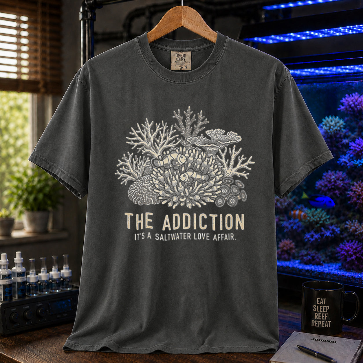 Broke Reefers saltwater aquarium graphic t-shirt featuring an intricate coral and clownfish illustration with the text: THE ADDICTION, IT'S A SALTWATER LOVE AFFAIR, khaki crew neck tee