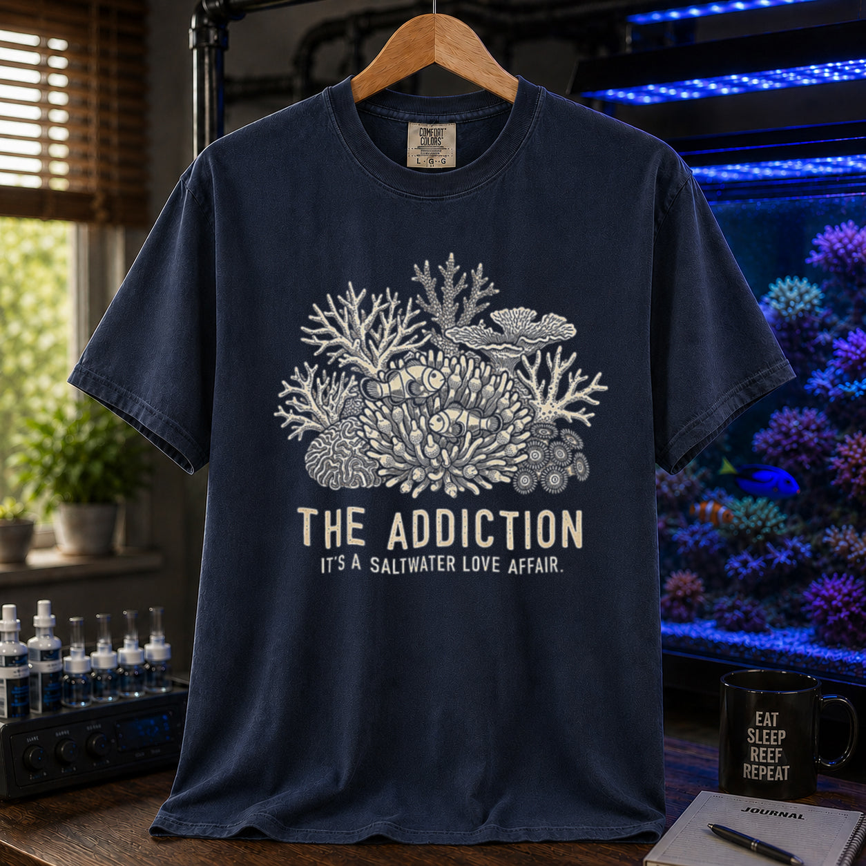 Broke Reefers saltwater aquarium graphic t-shirt featuring an intricate coral and clownfish illustration with the text: THE ADDICTION, IT'S A SALTWATER LOVE AFFAIR, navy crew neck tee