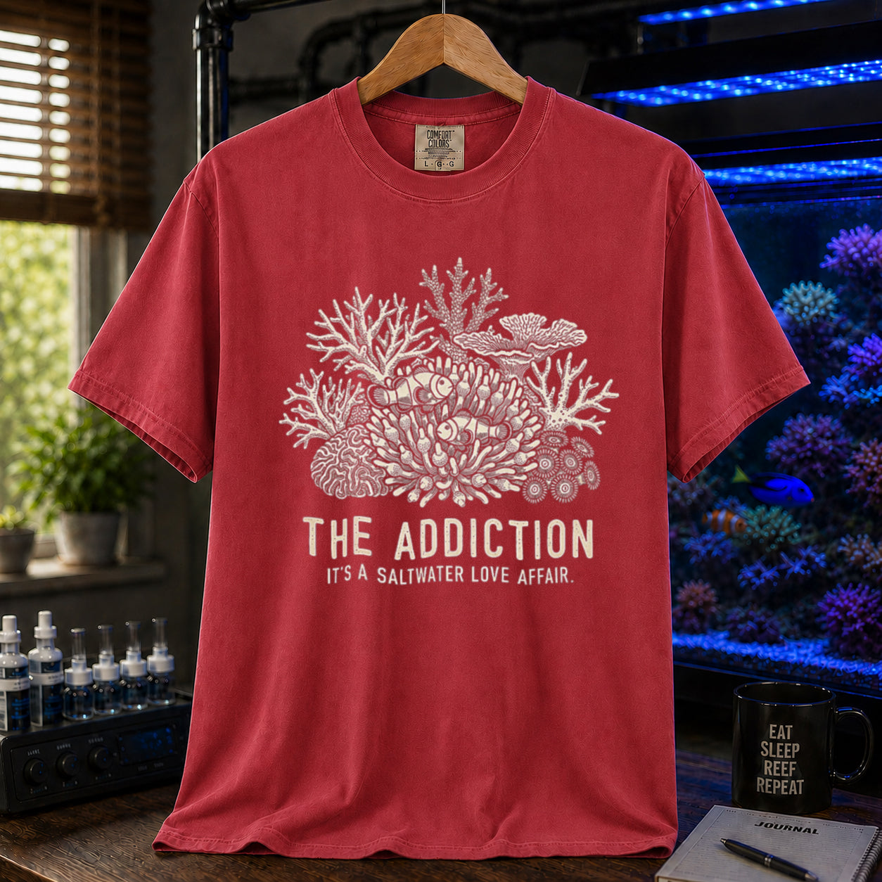 Broke Reefers saltwater aquarium graphic t-shirt featuring an intricate coral and clownfish illustration with the text: THE ADDICTION, IT'S A SALTWATER LOVE AFFAIR, red crew neck tee