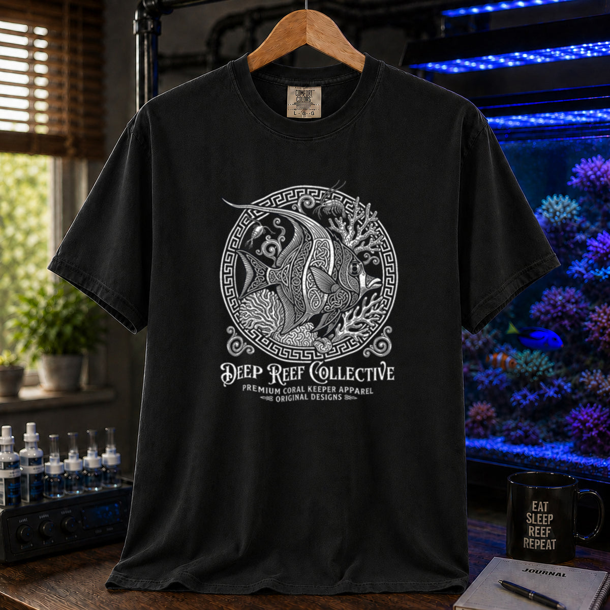 Deep Reef Collective saltwater aquarium graphic t-shirt featuring an ornate circular medallion illustration of a marine fish with the text: DEEP REEF COLLECTIVE, PREMIUM CORAL KEEPER APPAREL, ORIGINAL DESIGNS, black crew neck tee