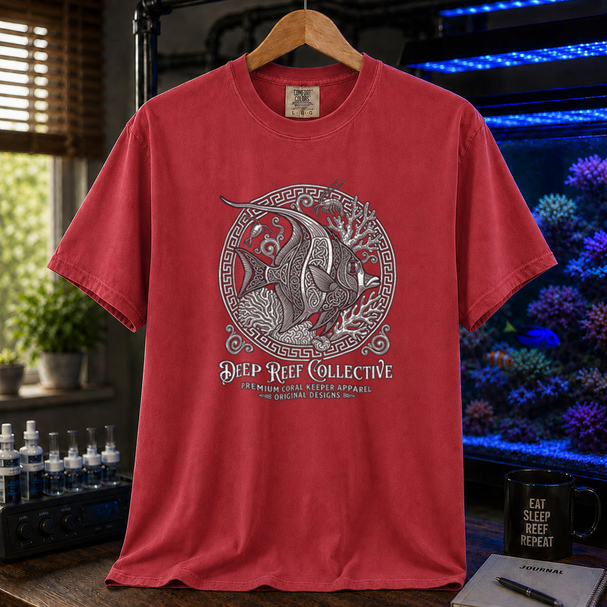 Deep Reef Collective saltwater aquarium graphic t-shirt featuring an ornate circular medallion illustration of a marine fish with the text: DEEP REEF COLLECTIVE, PREMIUM CORAL KEEPER APPAREL, ORIGINAL DESIGNS, red crew neck tee
