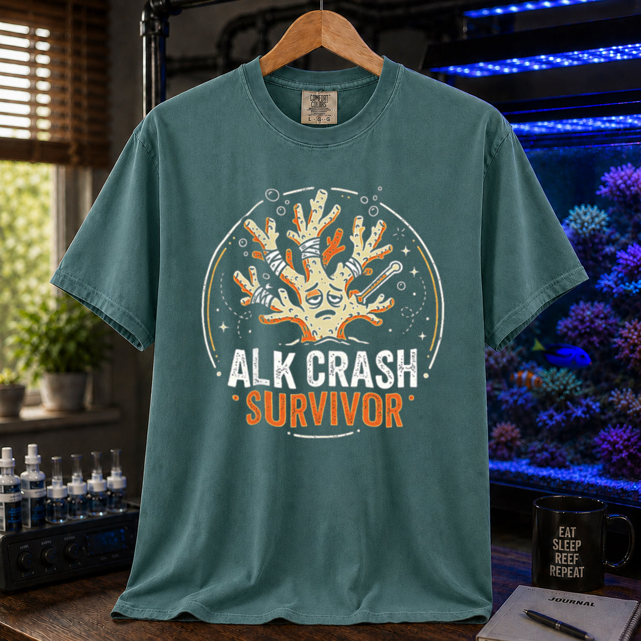Saltwater aquarium graphic t-shirt featuring a cartoon illustration of a bandaged coral and text: ALK CRASH SURVIVOR, green crew neck tee