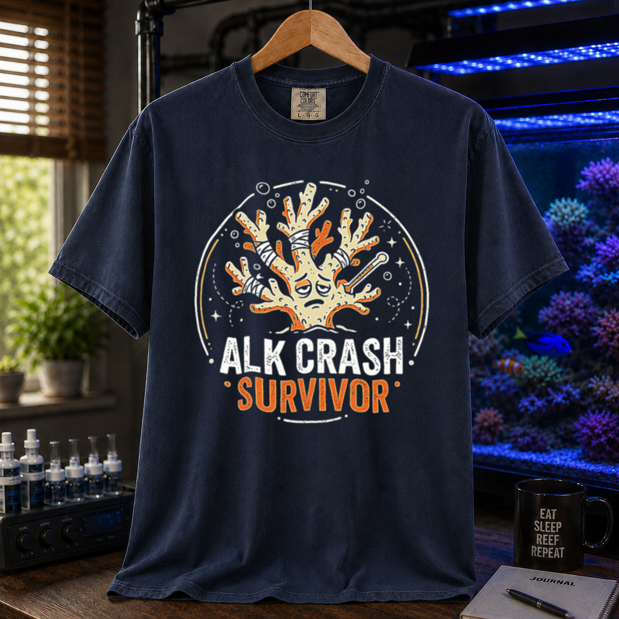 Saltwater aquarium graphic t-shirt featuring a cartoon illustration of a bandaged coral and text: ALK CRASH SURVIVOR, navy crew neck tee