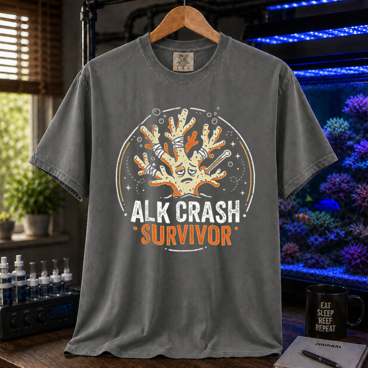 Saltwater aquarium graphic t-shirt featuring a cartoon illustration of a bandaged coral and text: ALK CRASH SURVIVOR, khaki crew neck tee