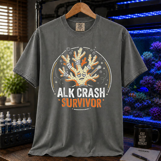 Saltwater aquarium graphic t-shirt featuring a cartoon illustration of a bandaged coral and text: ALK CRASH SURVIVOR, khaki crew neck tee