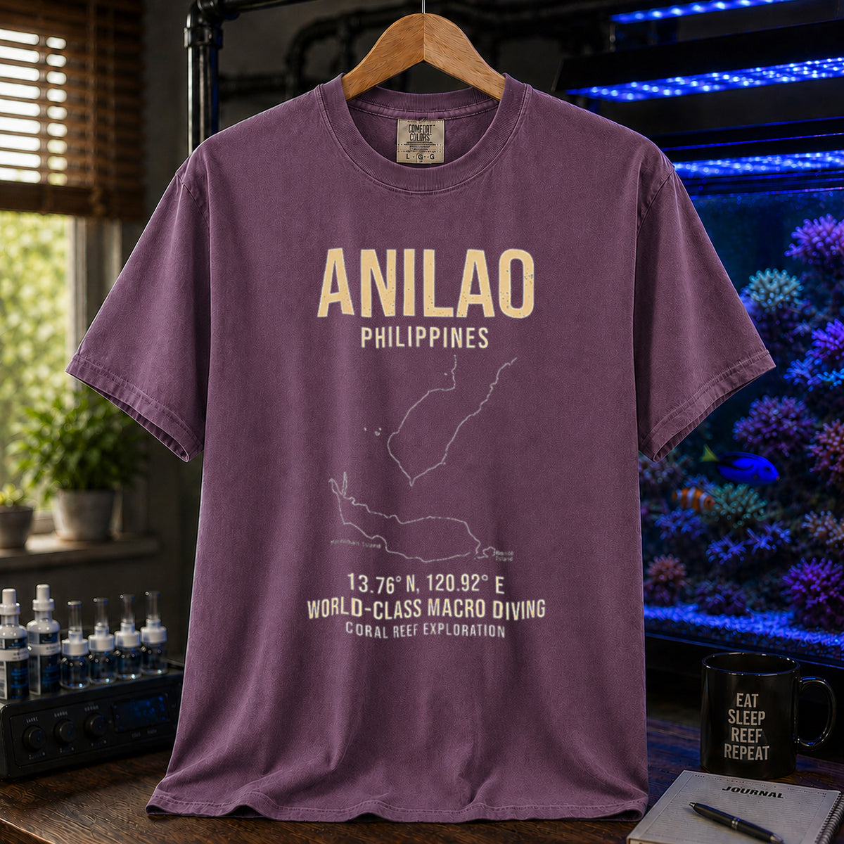 Saltwater aquarium graphic t-shirt featuring a map outline of Anilao, Philippines, coordinates, and the text: ANILAO PHILIPPINES, 13.76 N, 120.92 E, WORLD-CLASS MACRO DIVING, CORAL REEF EXPLORATION, purple crew neck tee