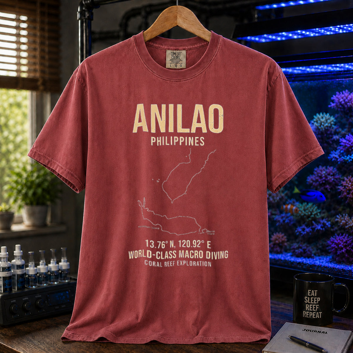 Saltwater aquarium graphic t-shirt featuring a map outline of Anilao, Philippines, coordinates, and the text: ANILAO PHILIPPINES, 13.76 N, 120.92 E, WORLD-CLASS MACRO DIVING, CORAL REEF EXPLORATION, maroon crew neck tee