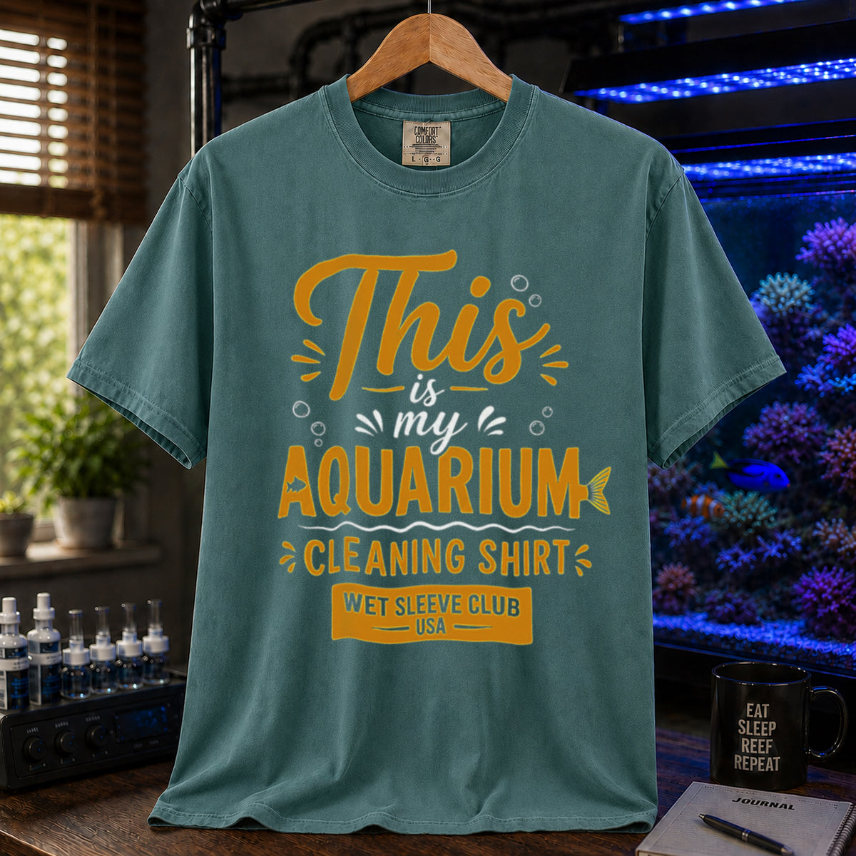 Saltwater aquarium graphic t-shirt featuring bold gold and white text: THIS IS MY AQUARIUM CLEANING SHIRT, WET SLEEVE CLUB USA, green crew neck tee