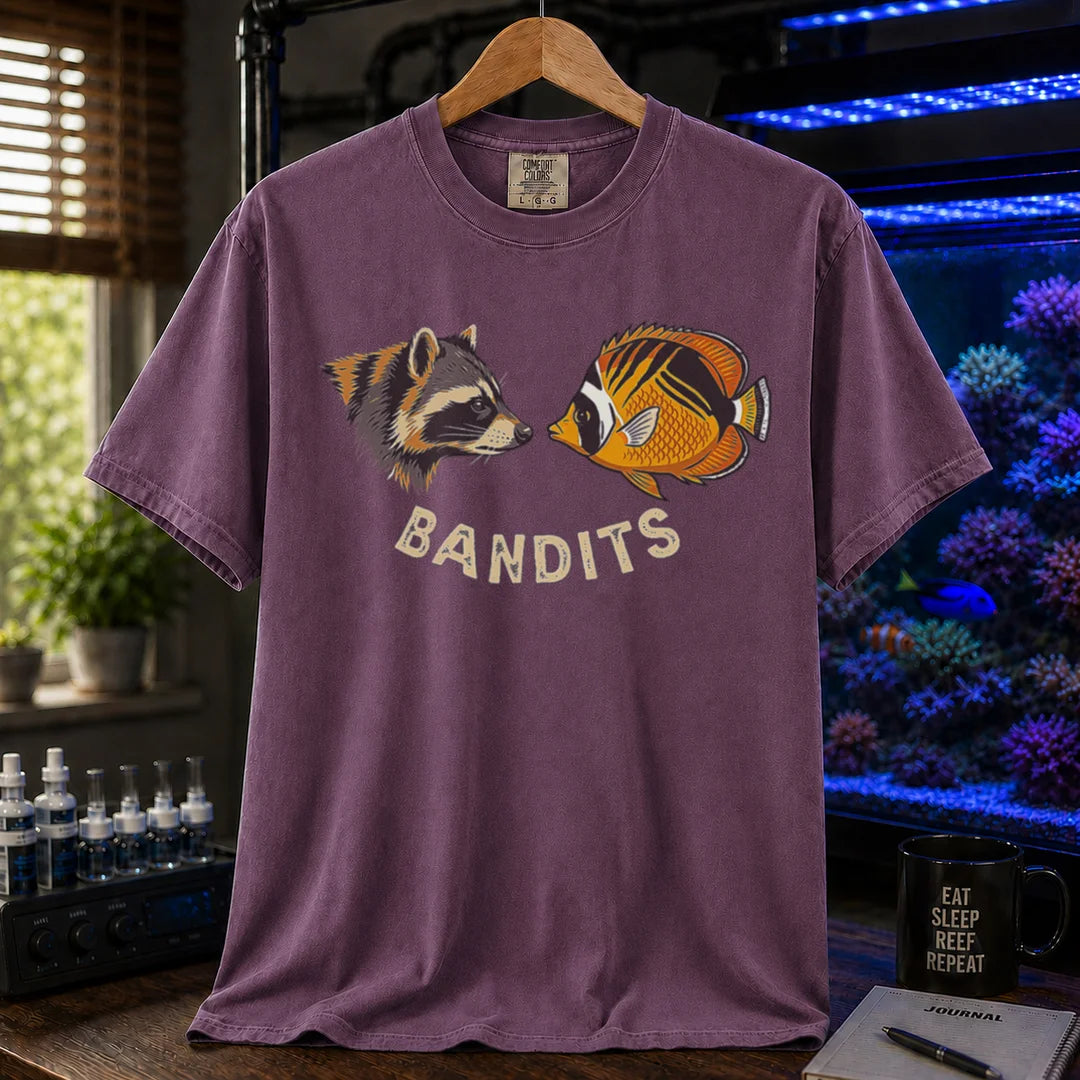 Saltwater aquarium graphic t-shirt featuring a vintage illustration of a raccoon and a Bandit Angelfish face-to-face with the text: BANDITS, purple crew neck tee