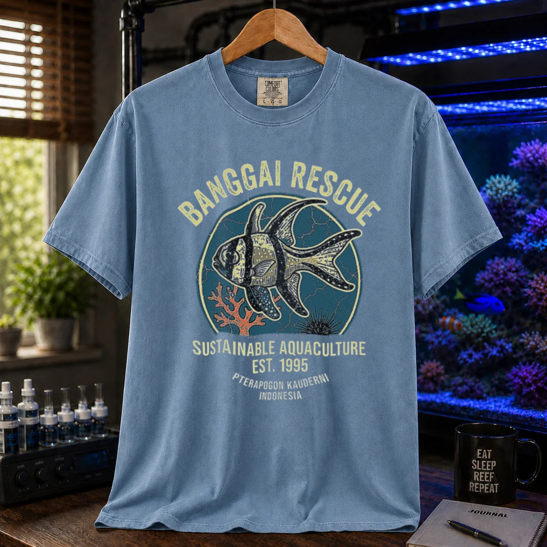 Saltwater aquarium graphic t-shirt featuring a retro emblem of a Banggai Cardinalfish and text: BANGGAI RESCUE, SUSTAINABLE REEFKEEPING, EST. 1995, PTERAPOGON KAUDERNI, INDONESIA, blue crew neck tee
