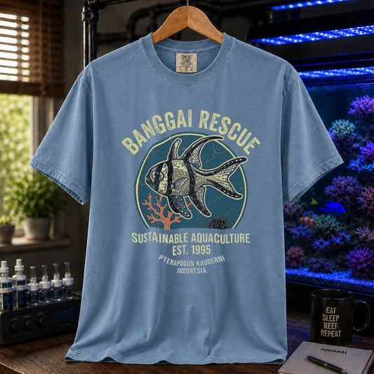 Saltwater aquarium graphic t-shirt featuring a retro emblem of a Banggai Cardinalfish and text: BANGGAI RESCUE, SUSTAINABLE REEFKEEPING, EST. 1995, PTERAPOGON KAUDERNI, INDONESIA, blue crew neck tee