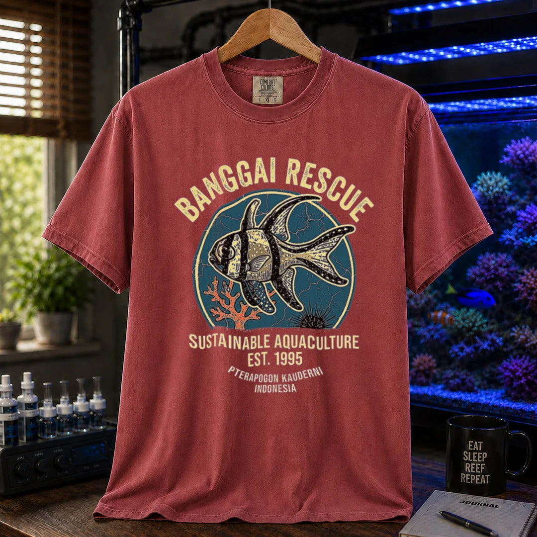 Saltwater aquarium graphic t-shirt featuring a retro emblem of a Banggai Cardinalfish and text: BANGGAI RESCUE, SUSTAINABLE REEFKEEPING, EST. 1995, PTERAPOGON KAUDERNI, INDONESIA, maroon crew neck tee