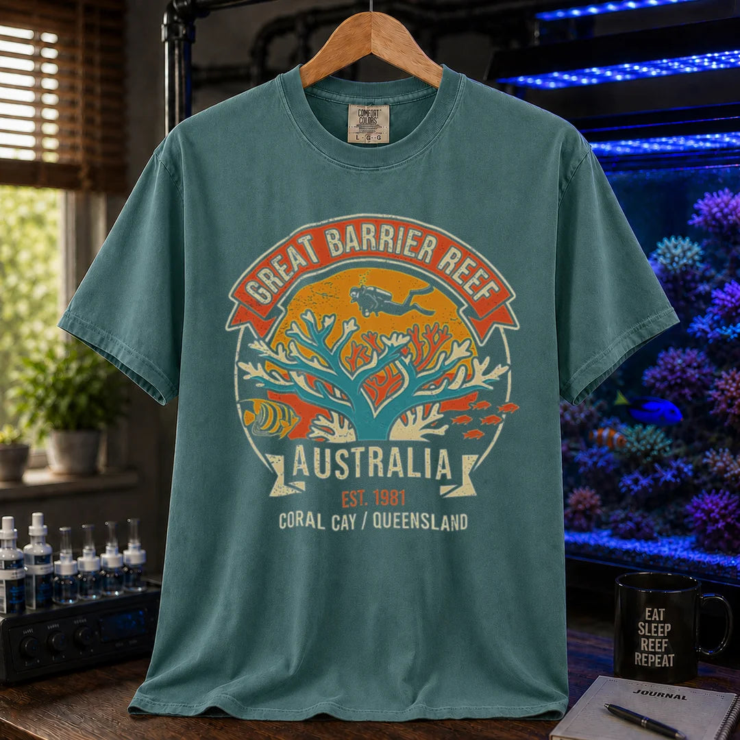 Saltwater aquarium graphic t-shirt featuring a retro colorful emblem of a scuba diver over a coral reef and text: GREAT BARRIER REEF, AUSTRALIA, EST. 1981, CORAL CAY / QUEENSLAND, green crew neck tee