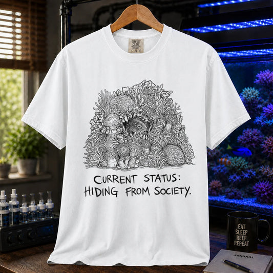 Saltwater aquarium graphic t-shirt on a pure solid white fabric background featuring an ink illustration of a fish hiding in coral and text: CURRENT STATUS: HIDING FROM SOCIETY,  white crew neck tee