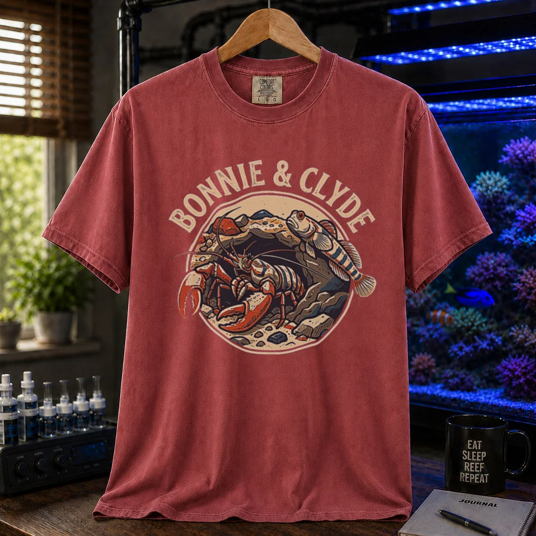 Saltwater aquarium graphic t-shirt featuring a retro emblem of a pistol shrimp and goby in a rock cave and text: BONNIE & CLYDE, maroon crew neck tee