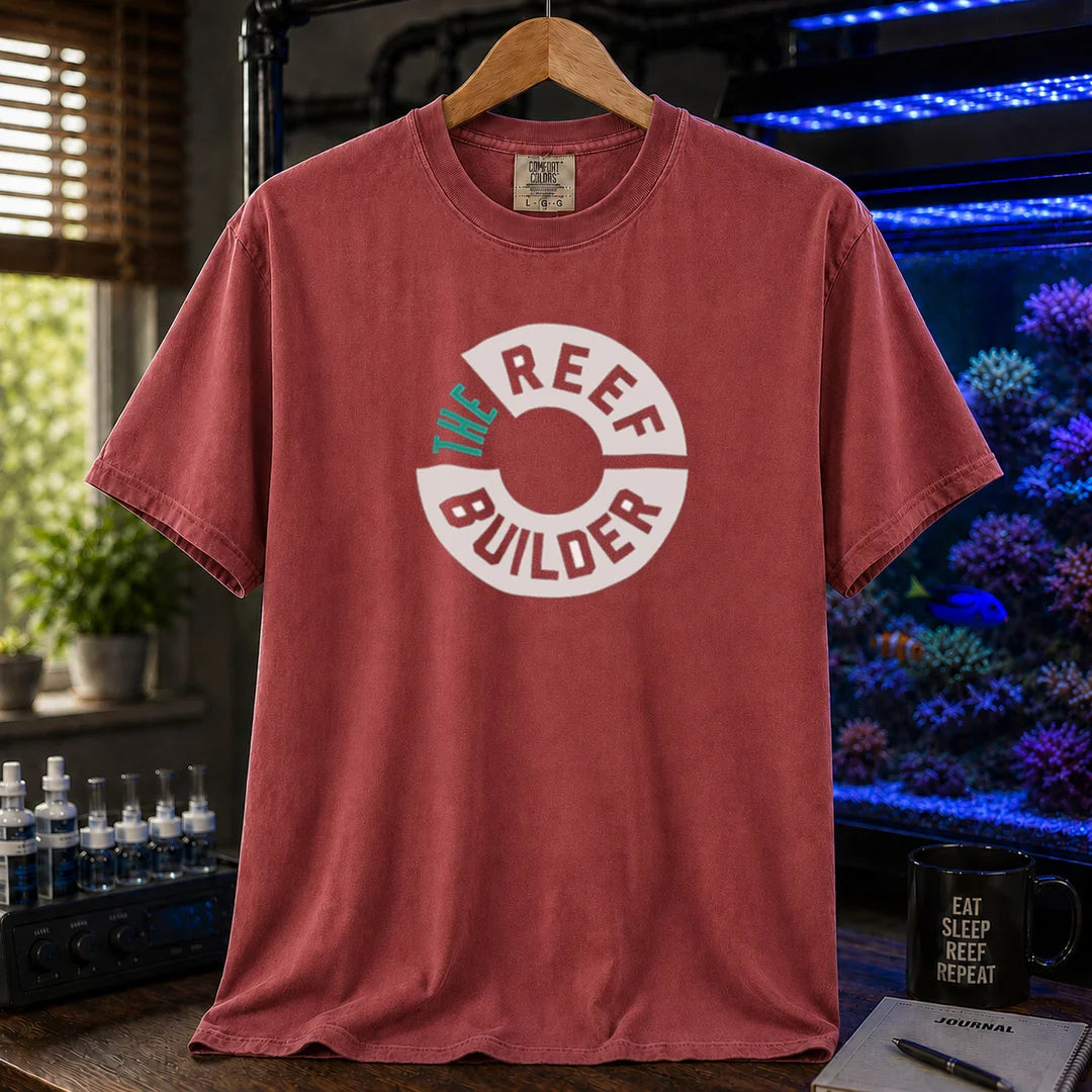 Saltwater aquarium graphic t-shirt featuring a circular badge with teal and white text reading: THE REEF BUILDER, maroon crew neck tee