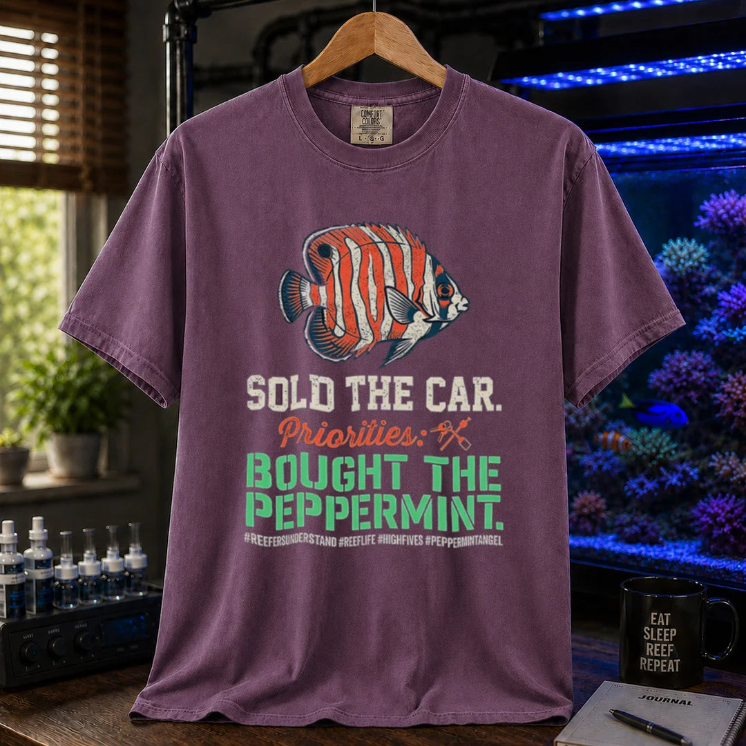 Saltwater aquarium graphic t-shirt featuring a Peppermint Angelfish illustration and text: SOLD THE CAR. Priorities: BOUGHT THE PEPPERMINT., purple crew neck tee