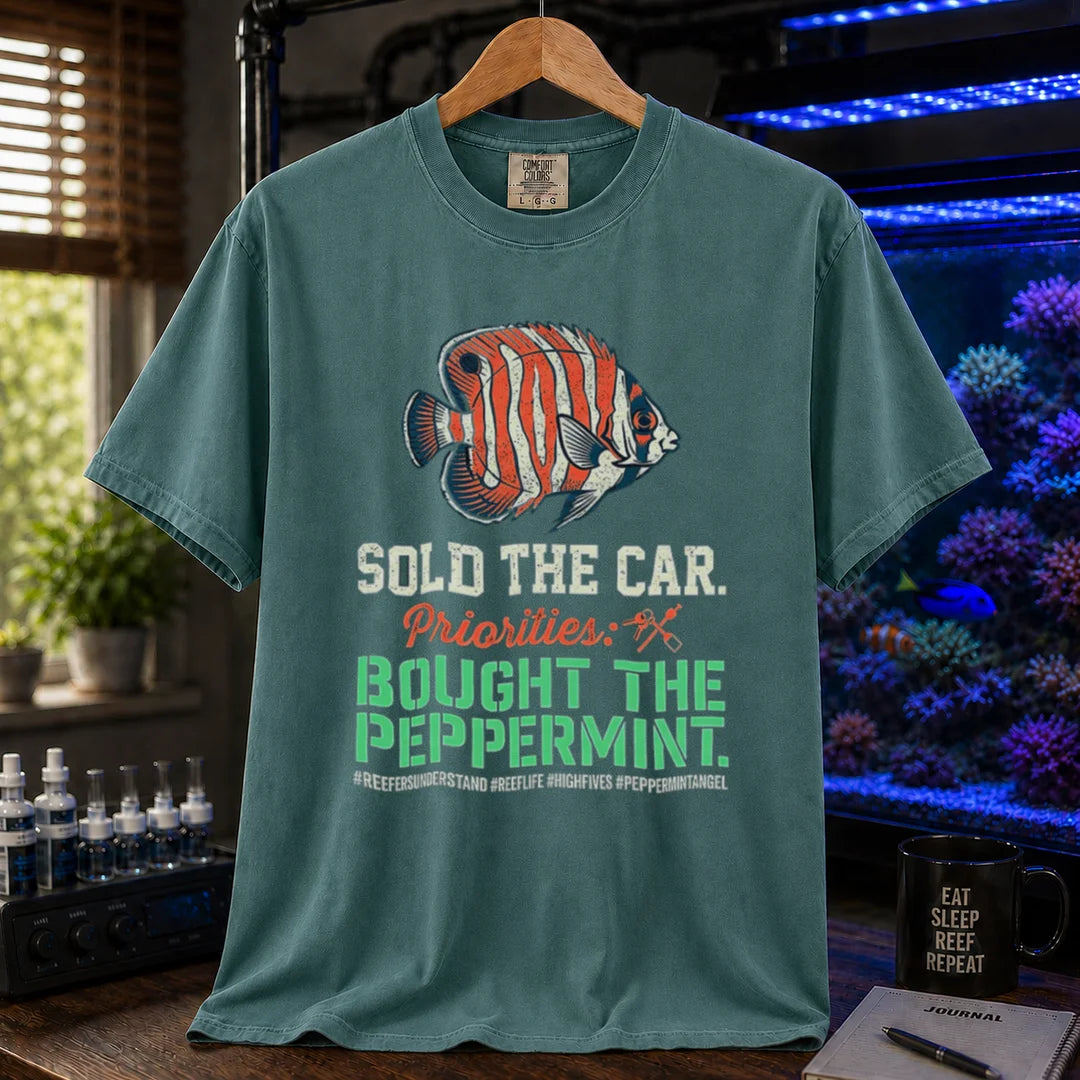 Saltwater aquarium graphic t-shirt featuring a Peppermint Angelfish illustration and text: SOLD THE CAR. Priorities: BOUGHT THE PEPPERMINT., green crew neck tee