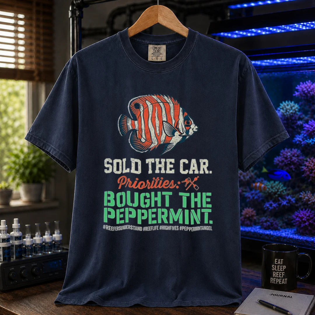 Saltwater aquarium graphic t-shirt featuring a Peppermint Angelfish illustration and text: SOLD THE CAR. Priorities: BOUGHT THE PEPPERMINT., navy crew neck tee