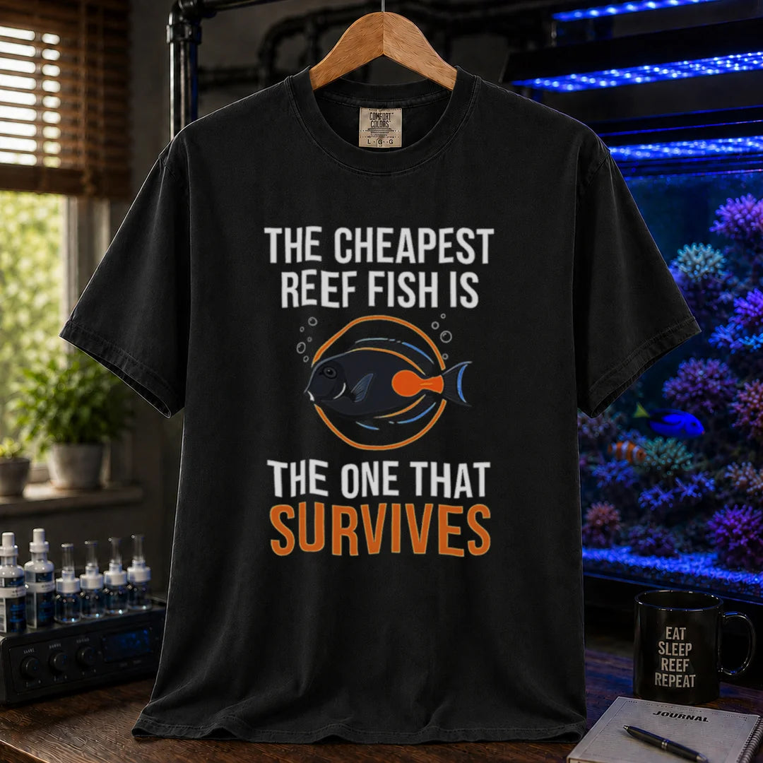 Saltwater aquarium graphic t-shirt featuring an Achilles Tang illustration inside a circular badge with text: THE CHEAPEST REEF FISH IS THE ONE THAT SURVIVES, black crew neck tee