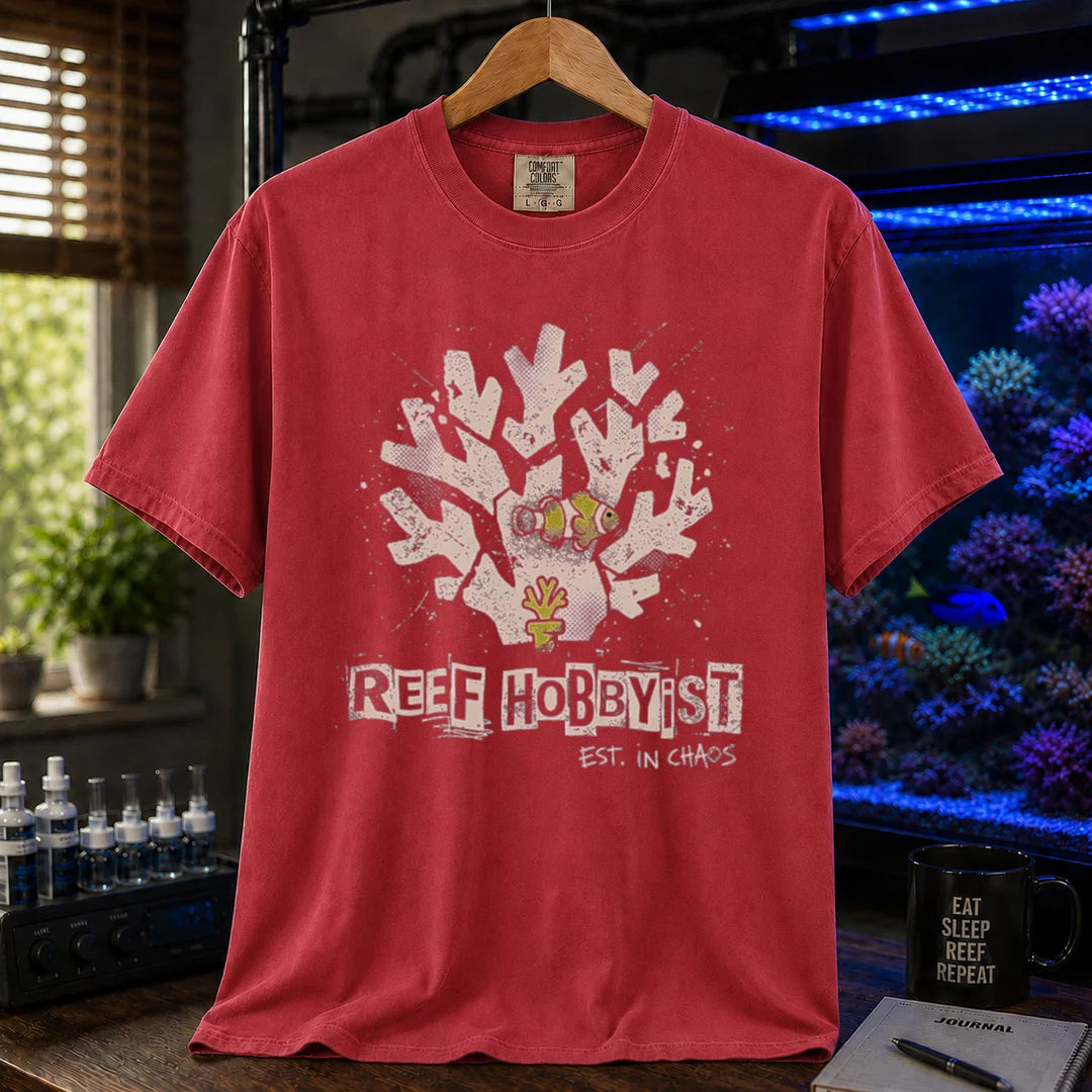 Saltwater aquarium graphic t-shirt featuring a distressed branching coral illustration with a clownfish and text: REEF HOBBYIST EST. IN CHAOS, red crew neck tee