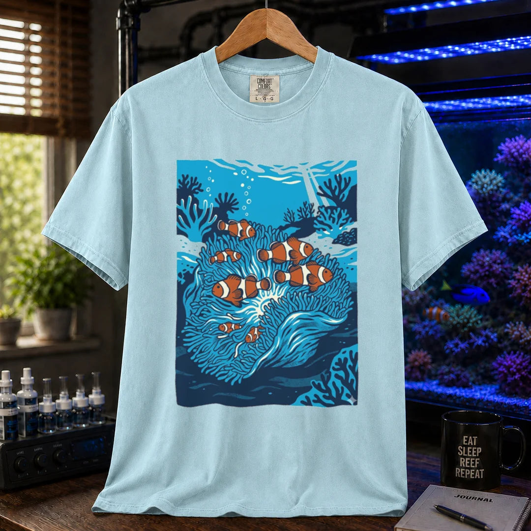 Saltwater aquarium graphic t-shirt featuring a vibrant illustration of multiple clownfish in a blue anemone biotope, light blue crew neck tee