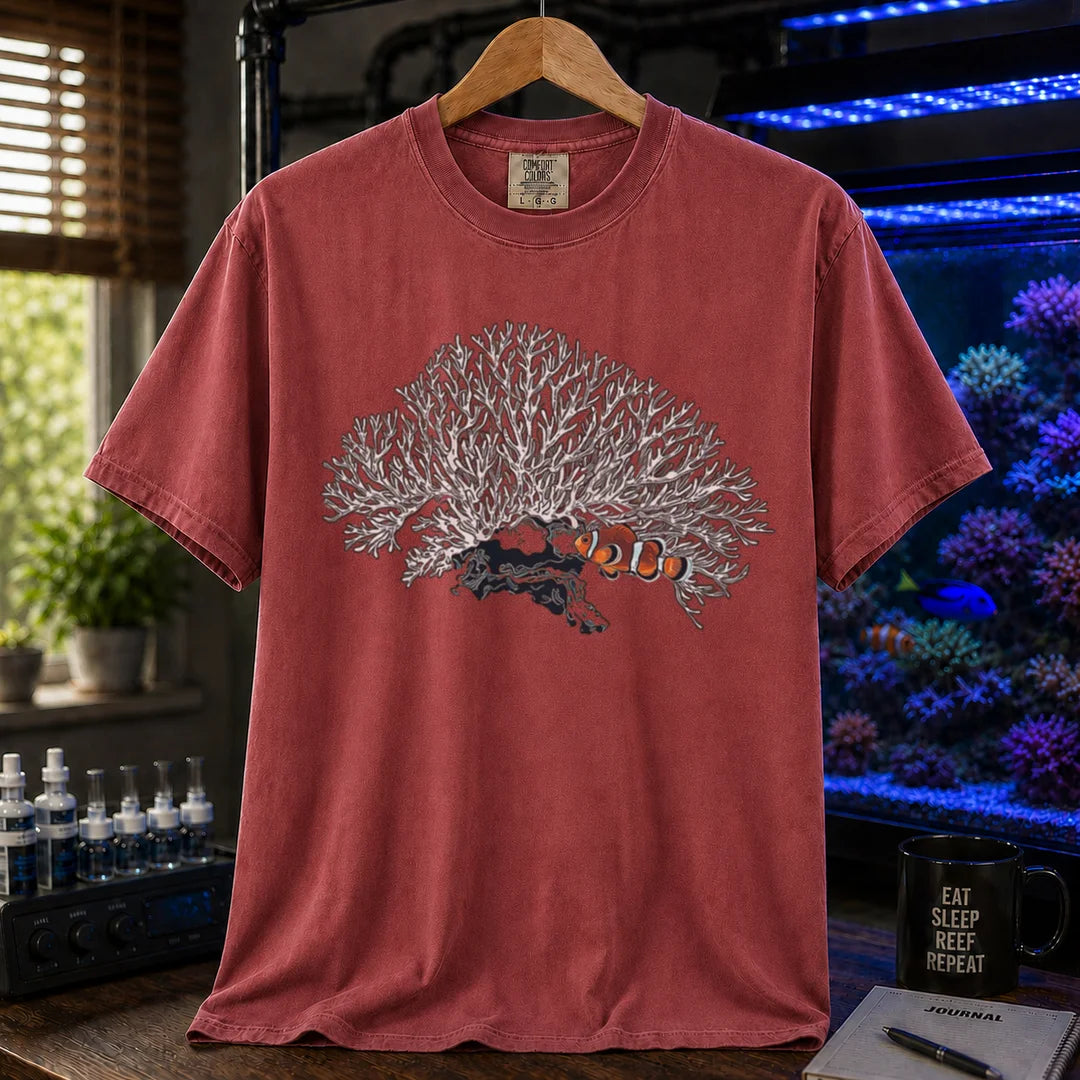 Saltwater aquarium graphic t-shirt featuring a detailed white branching coral illustration with a clownfish nestled underneath, maroon crew neck tee