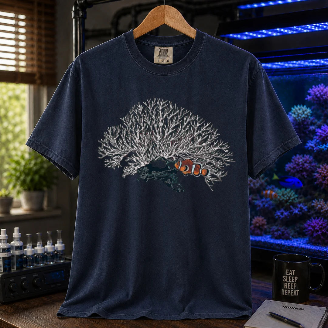 Saltwater aquarium graphic t-shirt featuring a detailed white branching coral illustration with a clownfish nestled underneath, navy crew neck tee